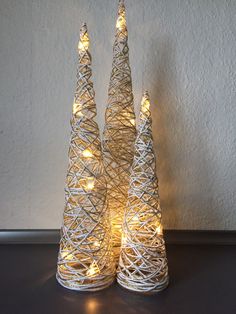 two small white christmas trees with lights on them