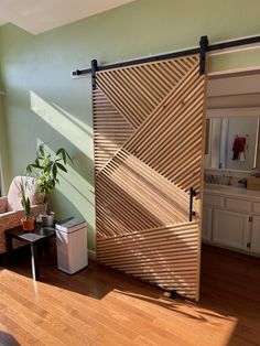 an open sliding door in a living room next to a chair and table with a potted plant on it