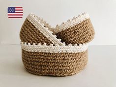 two woven baskets sitting on top of a white table next to each other, one is brown and the other is white