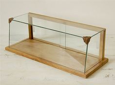 a glass display case sitting on top of a wooden shelf