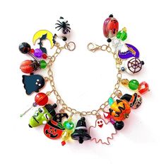 This happy and colorful Halloween charm bracelet is handcrafted by myself and a one of a kind original.  The gold plated chain is 7 3/4 inches long with 19 drops containing  pumpkins, jack o lanterns,  ghosts, a monster, cat, moon, bats and lots of crystals so it sparkles as you move.  It contains an assortment of enamel charms, Lampwork beads, glass, acrylic and crystals.  If you need it shorter or longer just let me know, and I will adjust it to as close as possible to the size you desire. If Monster Cat, Halloween Charm Bracelet, Colorful Halloween, Bats Halloween, Cat Moon, Halloween Charms, Halloween Jewelry, Enamel Charms, Gold Plated Chains