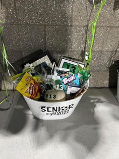 a bowl filled with assorted items sitting on top of a table next to a wall