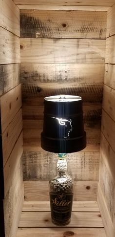 a lamp that is sitting on top of a table in a room with wooden walls