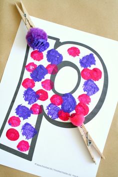 the letter p is made with tissue paper and pom - poms