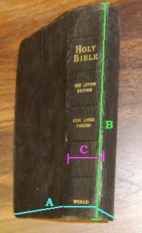 an old book with green lines on the front and back cover, sitting on a wooden surface