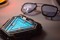 a pair of sunglasses sitting on top of a table next to an object that looks like a sci - fi device