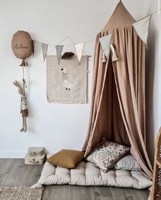 a bed with a canopy and pillows on the floor