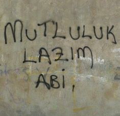 graffiti written on the side of a wall that says mutluk lazm abi