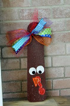 a turkey made out of toilet paper on top of a wooden shelf next to a brick wall