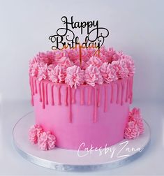 a birthday cake with pink icing and flowers