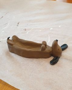 a clay animal laying on top of a piece of paper