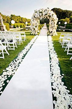 the aisle is lined with white flowers and petals