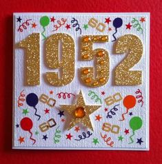 a white card with gold numbers and balloons