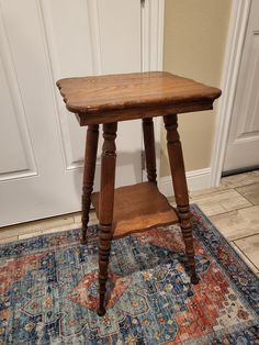 a wooden table sitting on top of a rug in front of a white door way