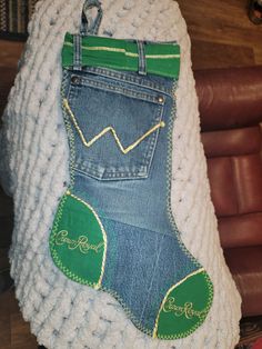 a pair of blue jeans with green patches on them are hanging from a white sweater