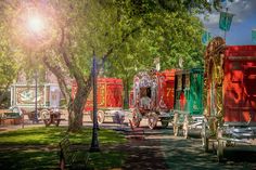 colorfully painted horse drawn carriages are parked in the park