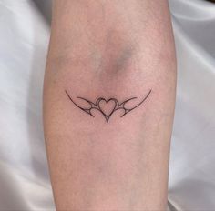 a tattoo on the leg of a woman with two birds flying in the shape of a heart