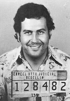 an old photo of a man with a license plate on his shirt smiling for the camera