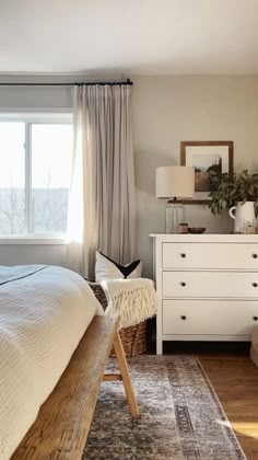 a white bed sitting next to a window in a bedroom