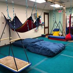 an indoor play area with hammocks and swings