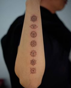 a person with a tattoo on their arm that has seven chakras in it