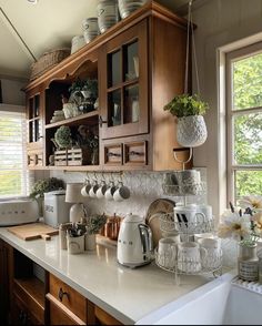 a kitchen with wooden cabinets and white counter tops, filled with pots and pans