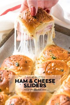 ham and cheese sliders being lifted from a baking pan