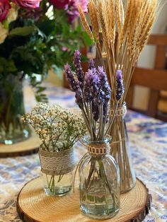 three vases filled with flowers sitting on top of a table