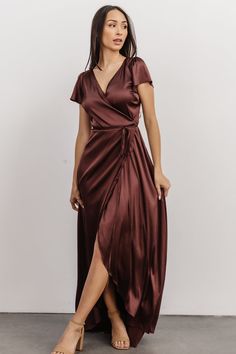 Baltic Born exclusive style! Feel glamorous in an instant with this stunning gown Luminous dark clove, purple brown color Satin material with slight stretch and lots of shine True wrap style with V-neckline Short flutter sleeves Wrap ties at waist loop through a hole in the side to tie Maxi length with tulip style skirt Silhouette creates movement and shows just enough leg Fully lined Self: 93% Polyester, 7% Spandex Lining: 100% Polyester For larger busts, we recommend sizing up for additional coverage if desired Trina is 5'6, cup size 32D, size 2 and is wearing size S Sophia is 5'5, cup size 32D, size 0 and wearing size S Victoria is 5'7, cup size 38C, size 16/18 and wearing size 1XL Satin Wrap Dress, Maid Of Honour Dresses, Baltic Born, Stunning Gowns, Dress Satin, Style Skirt, Satin Material, Dress Cuts, Flutter Sleeves