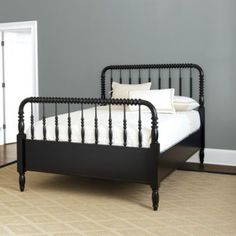 a black metal bed frame in a bedroom