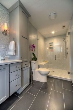 a white toilet sitting next to a walk in shower