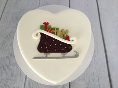 a cake shaped like a sleigh with presents in it on a white plate