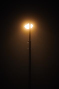 a street light in the dark on a foggy night