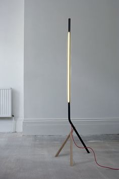 a black and white lamp sitting on top of a wooden stand next to a radiator