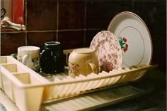 dishes and cups are sitting in a dish rack