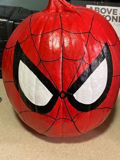 a spiderman pumpkin sitting on top of a table