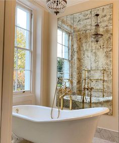 a bathroom with a claw foot bathtub and chandelier hanging from the ceiling