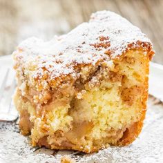 a piece of cake with powdered sugar on top is sitting on a plate next to a fork