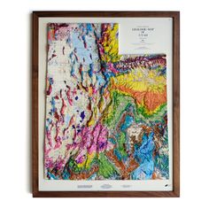 a framed map of the united states with colorful paint on it's paper and wood frame