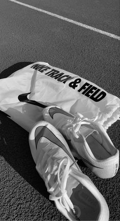 a pair of tennis shoes sitting on the ground next to a bag