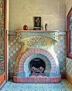 an ornate fireplace in the corner of a room with tile flooring and colorful wallpaper