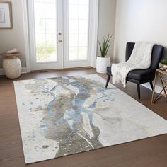 a living room area with a rug, chair and potted plant on the floor