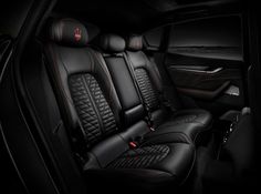 the interior of a car with black leather and red stitching