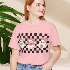 ABOUT OUR Checkered Ghost Tee, Halloween Checkered Ghost Shirt, Cute Ghost Tee, Cute Pink Ghost T-shirt, Retro Checkered Ghost Bow T-shirt   Get ready for a spook-tacular Halloween with our adorable checkered ghost tee! This cute ghost design is perfect for read lovers and anyone who loves a touch of pink in their wardrobe. The checkered pattern adds a playful touch, making this tee a must-have for the season. Our ghostly friend is sure to cast a spell on you, with its sweet expression and rosy Cute Halloween T-shirt For Streetwear, Cute Halloween Short Sleeve Tops, Cute Halloween Streetwear Tops, Pink Halloween Graphic Tee, Cute Short Sleeve Halloween Tops, Cute Tops For Halloween Streetwear, Pink Cotton T-shirt For Halloween, Cute Short Sleeve Tops For Halloween, Spooky Cotton Top With Funny Print