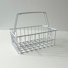 a white wire basket sitting on top of a table