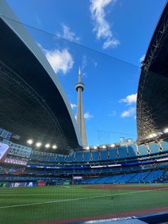 the inside of a baseball stadium with blue seats and a view of the sky tower in the background