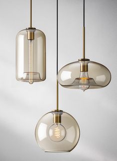 three glass pendant lights hanging from a ceiling