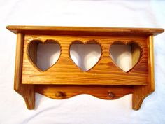 a wooden shelf with three hearts cut out of it's sides on a white background