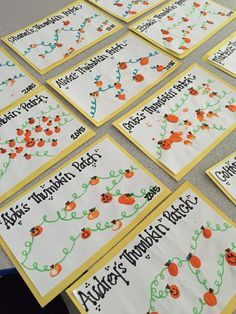 a table topped with lots of cards covered in orange and green writing next to each other