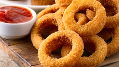 fried onion rings with ketchup and dipping sauce on the side, ready to be eaten